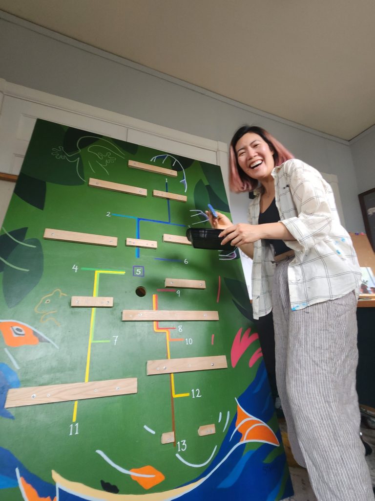 Sharon Tang painting the background of the Hox display
