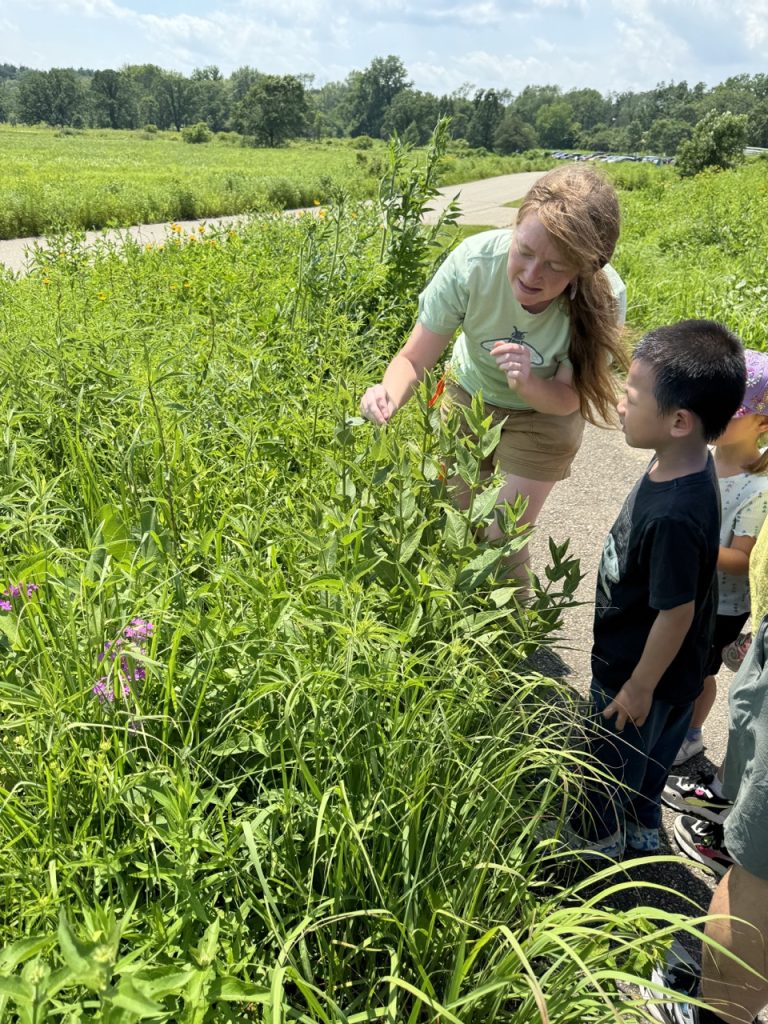 Kohler fellow showing a young child a milkweed plant