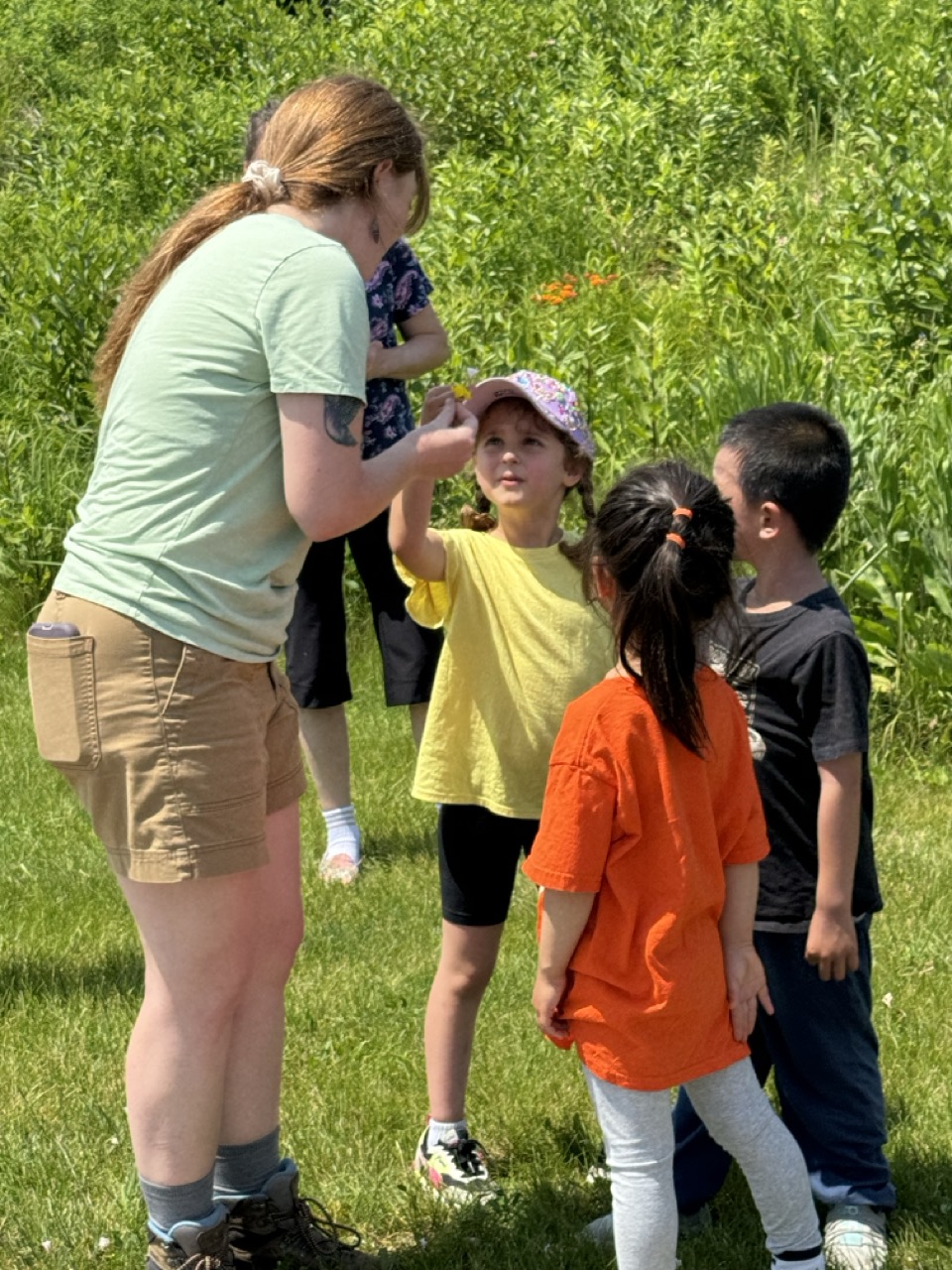 Celeste Huff showing children a specimen in the UW arboretum